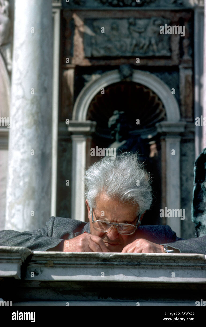 Europa Italia Venezia un anziano turista scrive una cartolina alla base del Campanile Foto Stock