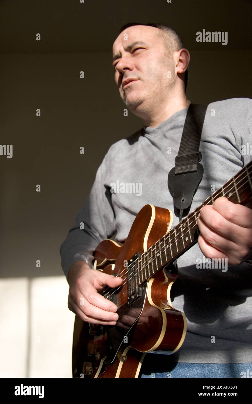 L'uomo gioca semi acoustic guitar elettrico modello rilasciato Foto Stock