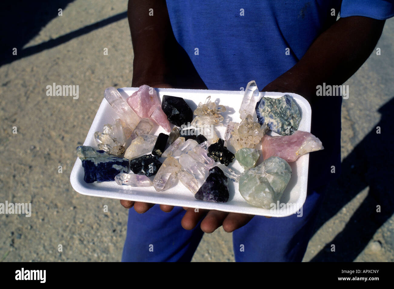 Un locale dal Uis visualizza una selezione di grezzo di semi-preziose pietre preziose in un vassoio Foto Stock