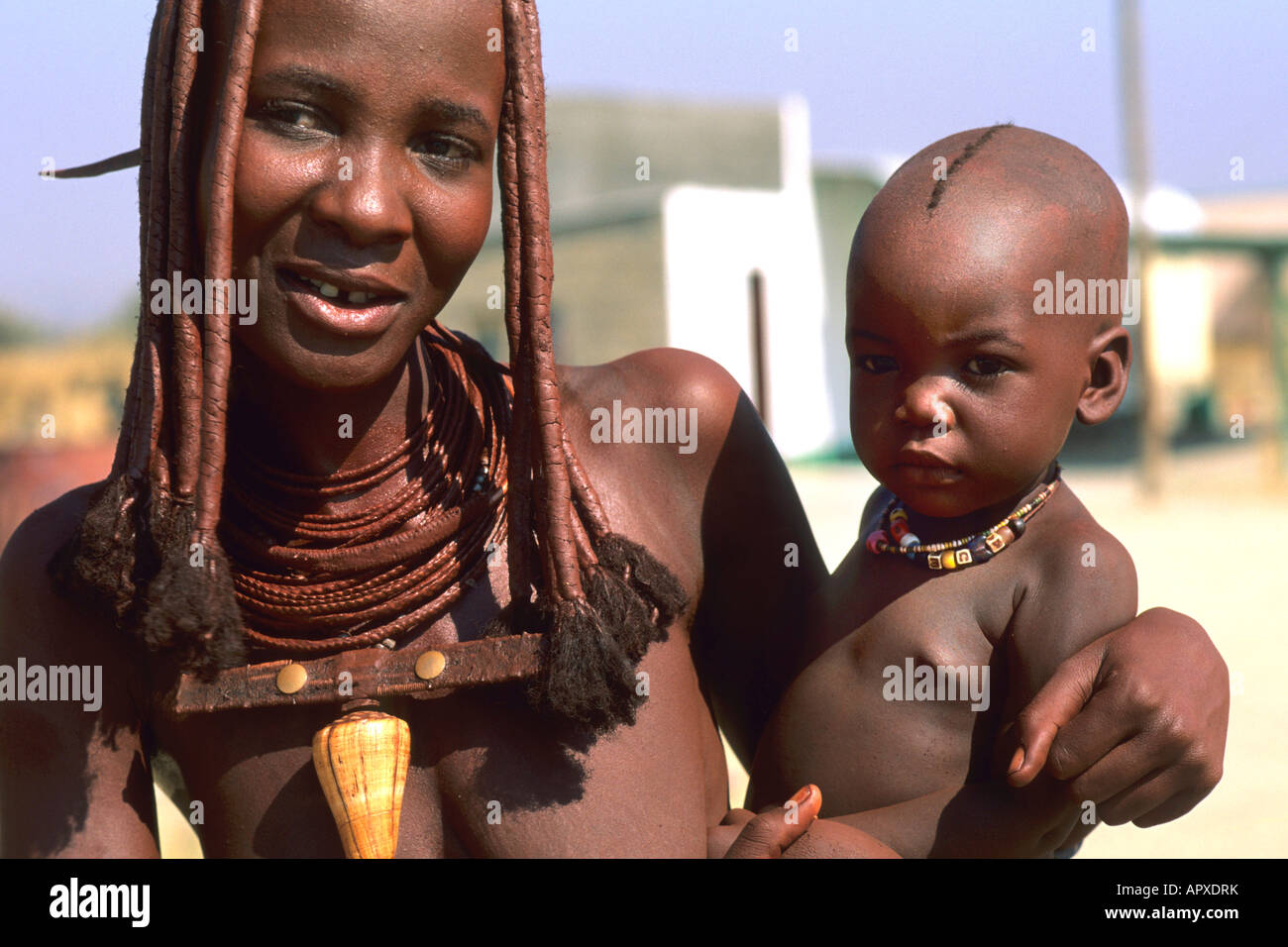 Un giovane Himba madre detiene il suo bambino sul suo hip Foto Stock