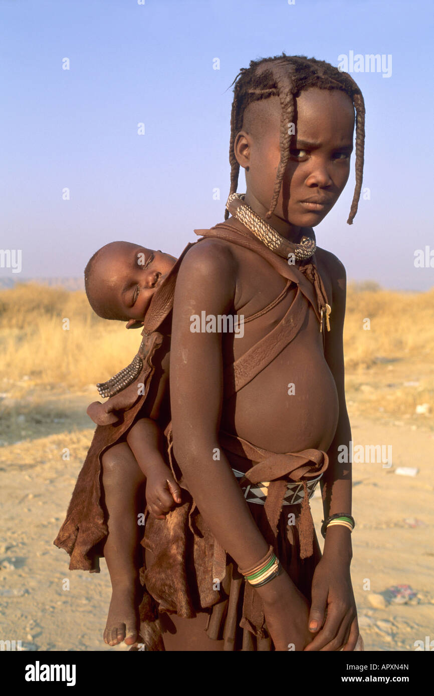 Giovane ragazza Himba porta un bambino sulla schiena Foto Stock