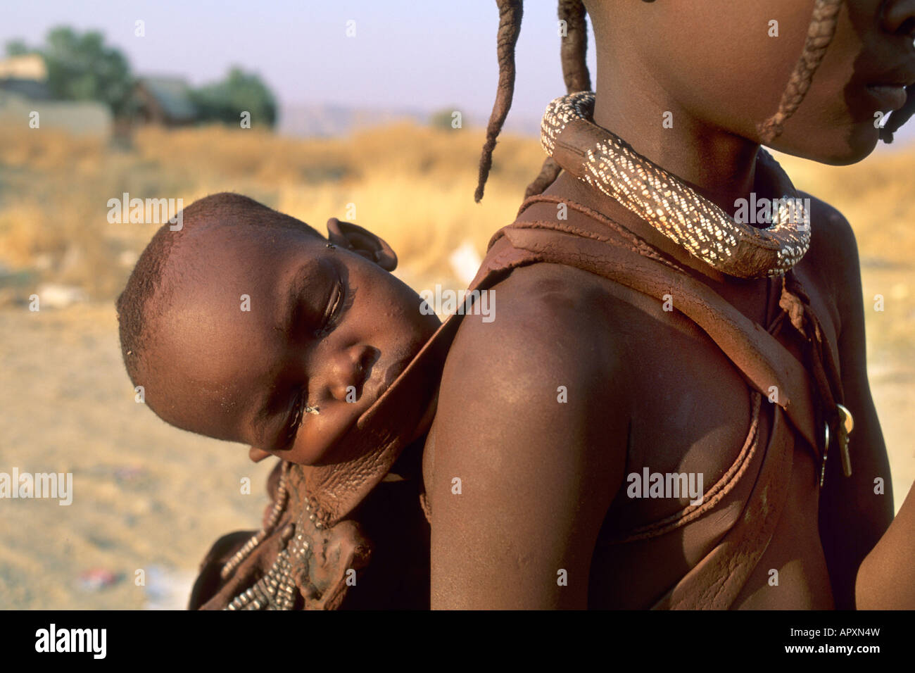 Close up di un Himba bambino che dorme sul retro di una giovane ragazza Foto Stock