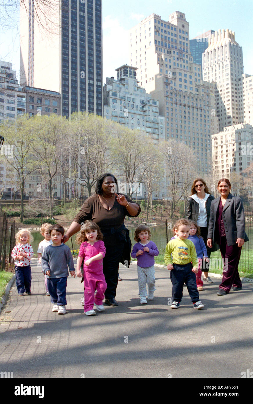 Gruppo di bambini che vengono adottate per Central Park di baby-sitter. Foto Stock