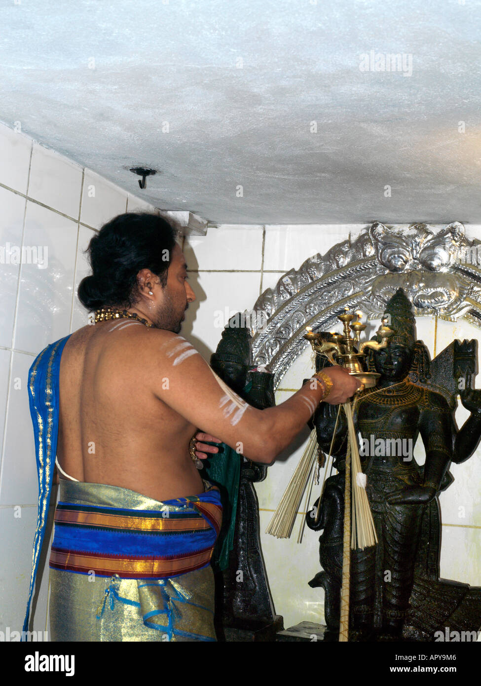 Murugan Temple New Malden Surrey in Inghilterra sacerdote utilizzando lampade a olio durante il bagno Murugans Foto Stock