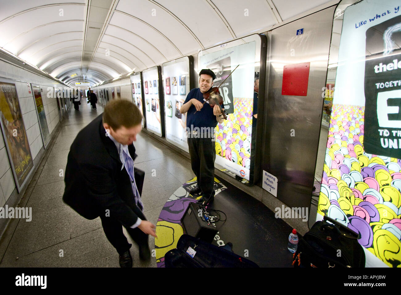 Un suonatore ambulante suona il violino in un tunnel per collegare il tubo le stazioni della metropolitana di Londra il 5 dicembre 2007 Foto Stock