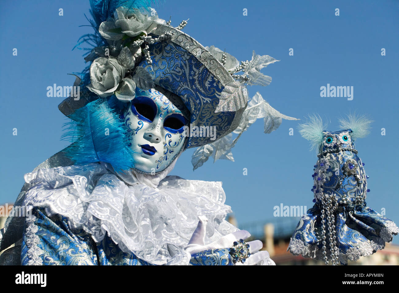 Carnevale di Venezia - Uomo in bianco e blu costume con un giocattolo owl Foto Stock