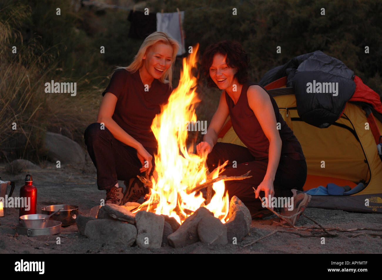 Due donne sedeva intorno al fuoco, Camping, Andalusia, Spagna Foto Stock