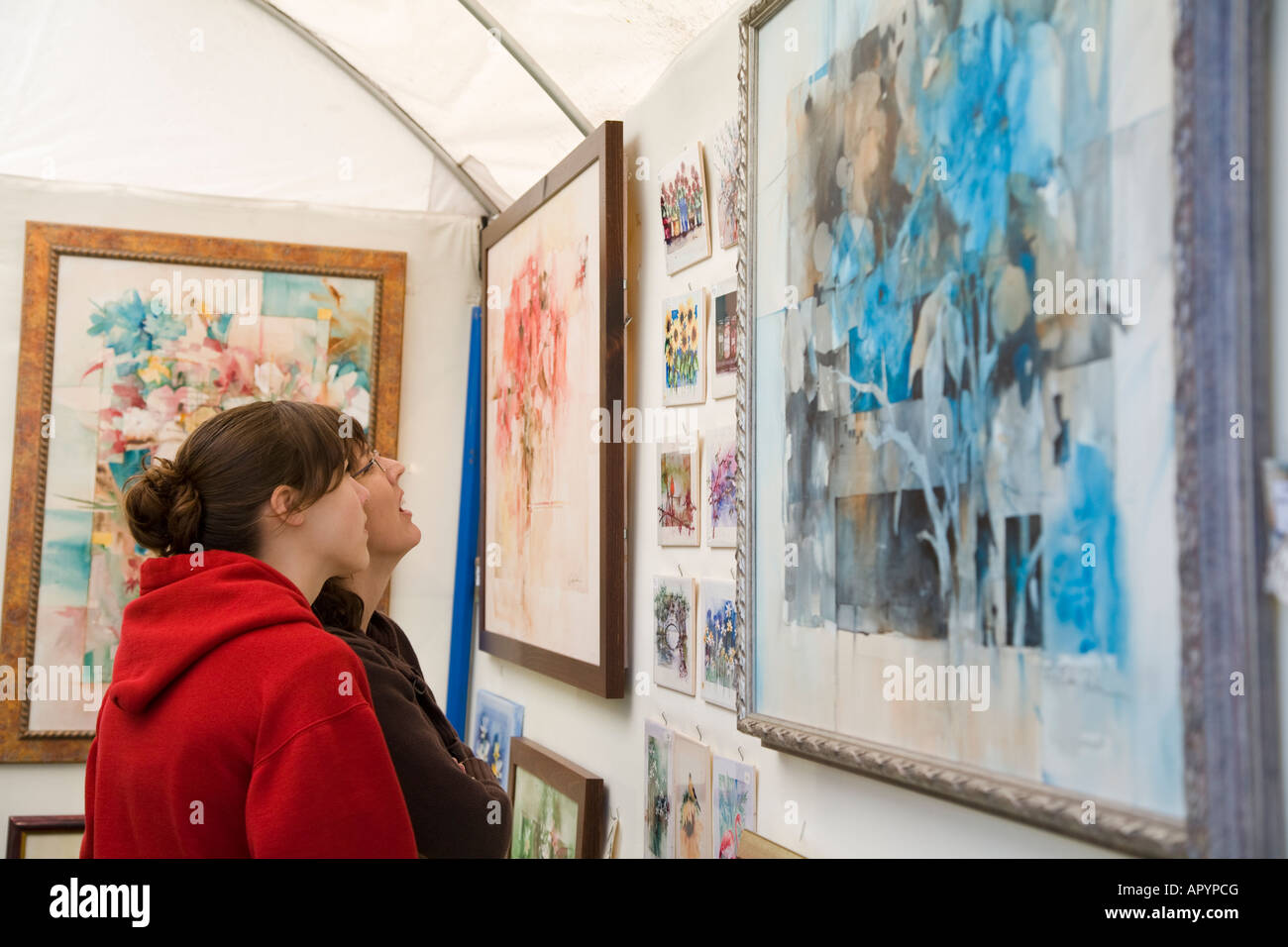 IOWA Est Davenport due donne guardando arte esposte per la vendita in stand Riverssance Festival di Arte Foto Stock