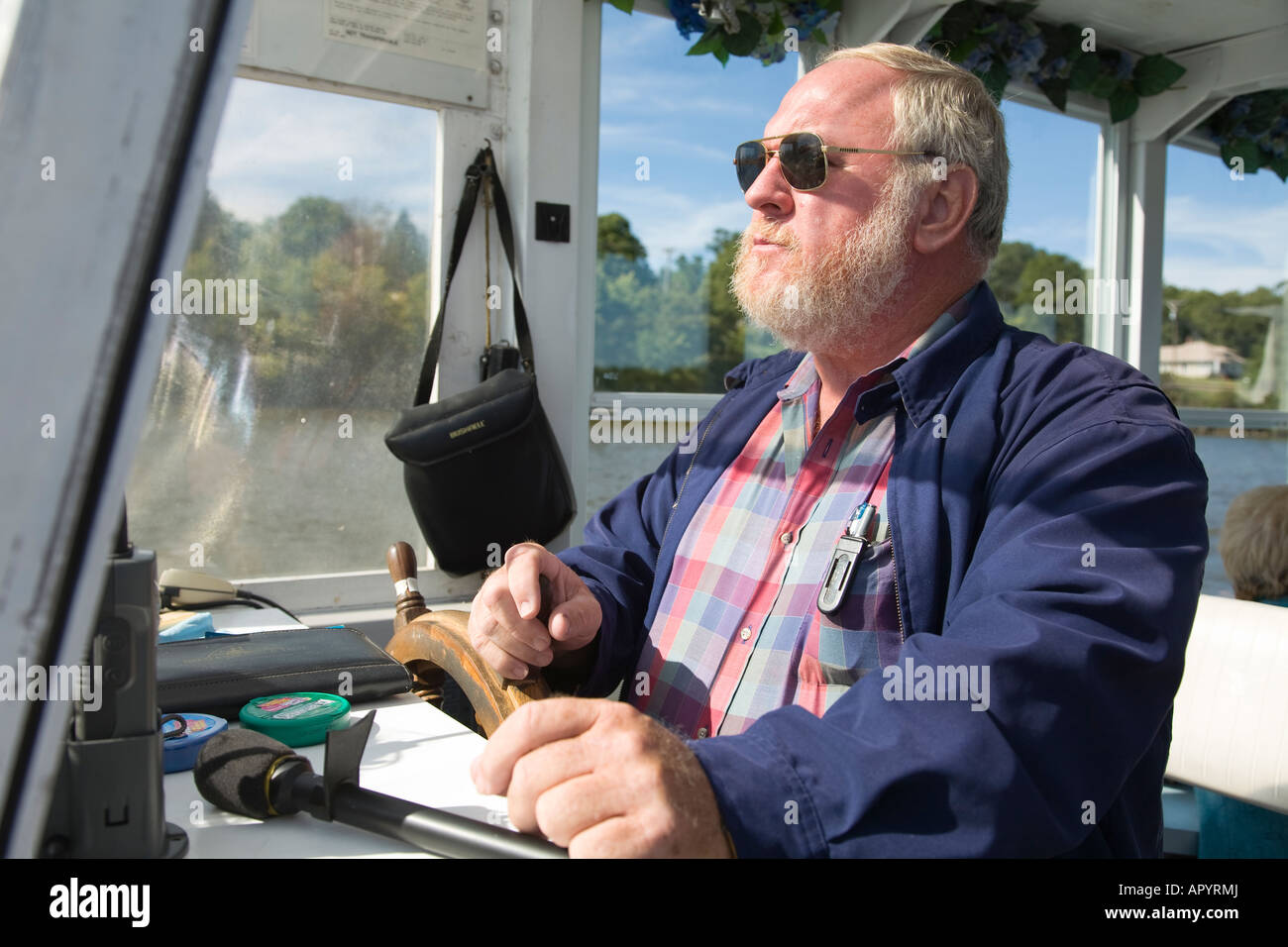 IOWA LeClaire il capitano del fiume tour in barca sul fiume Mississippi al volante guardando avanti indossando occhiali da sole Foto Stock