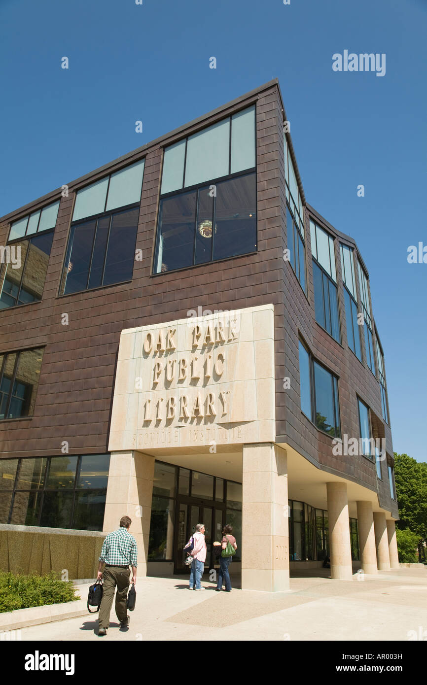 ILLINOIS Oak Park uomo a camminare verso la biblioteca pubblica di due donne in piedi parlando esterne di edifici Foto Stock