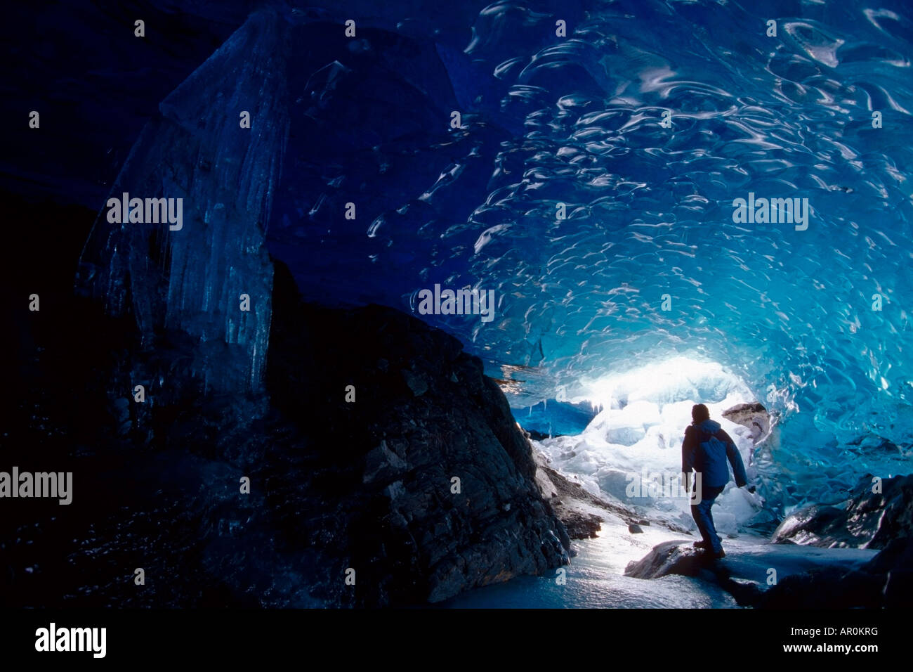 Escursionista Mendenhall Glacier esplorando la Grotta di Ghiaccio di sud-est AK Foto Stock