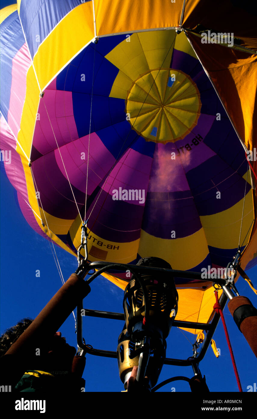 Un pilota di sguardi fino all'interno di una mongolfiera come egli aziona una raffica di gas Foto Stock