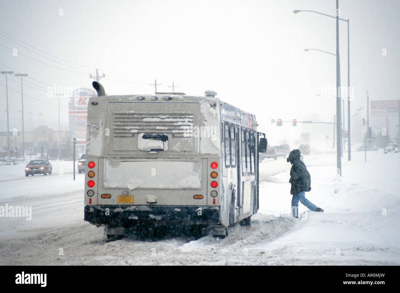 Uomo di salire sul bus della città in caso di maltempo Anchorage AK Foto Stock