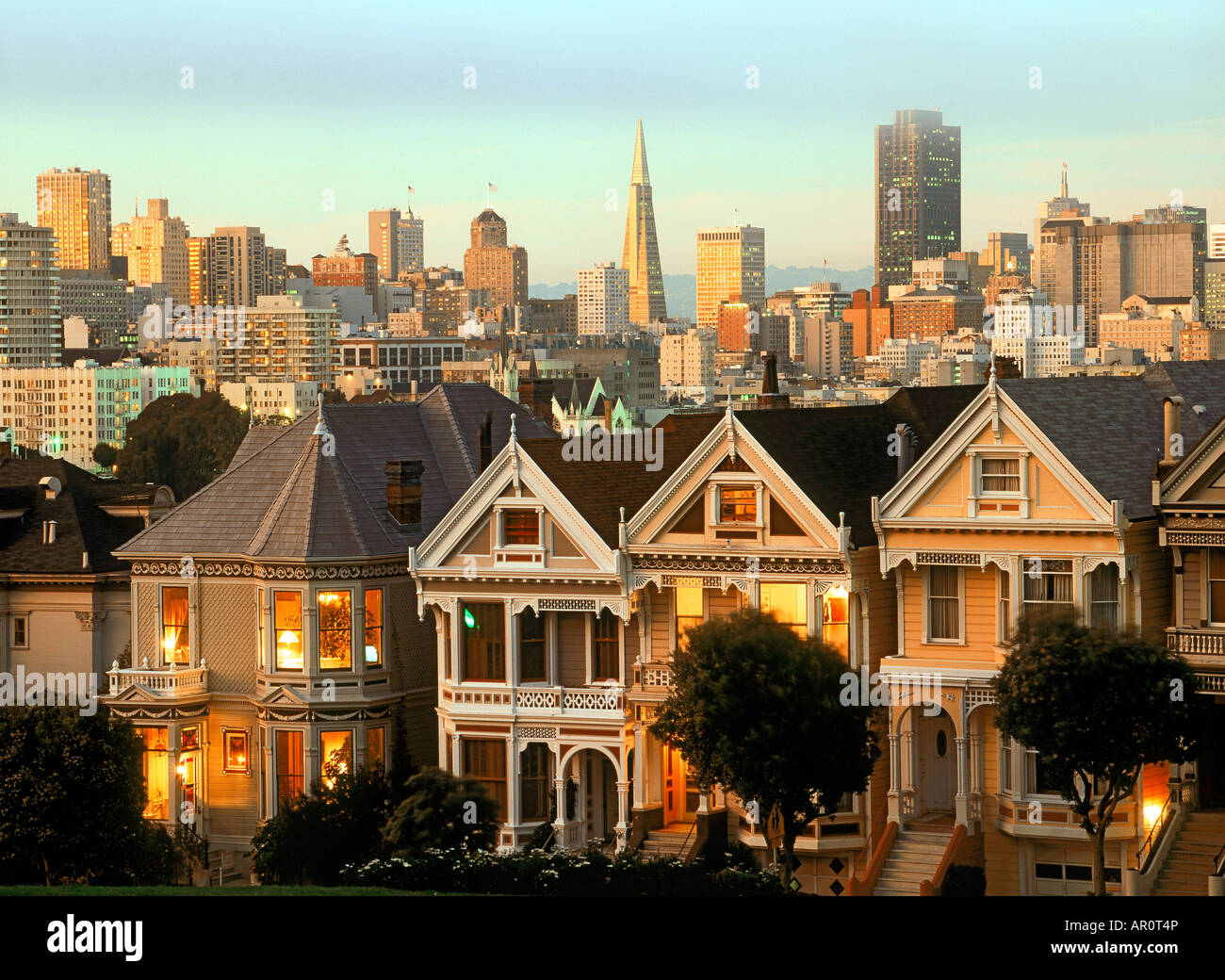 Case vittoriane lungo Steiner Street al crepuscolo con skyline di San Francisco Foto Stock