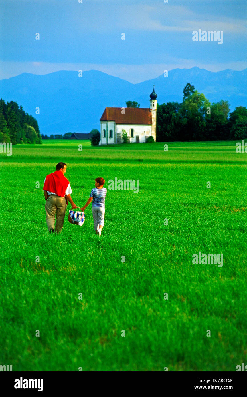 Padre e figlia con Cesto picnic attraversando fattorie in Baviera nei pressi di Monaco di Baviera, Germania Foto Stock