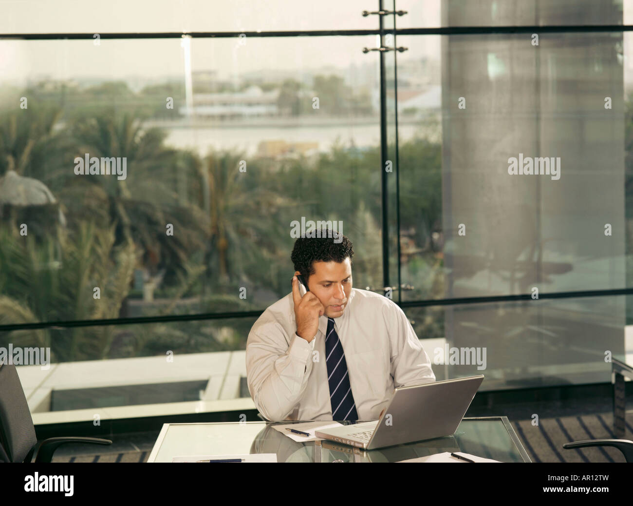 Imprenditore in ufficio parlando al telefono Foto Stock