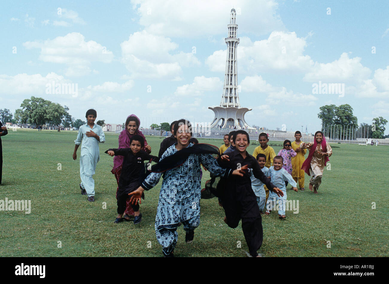 I bambini giocano prima della Minar-e-Pakistan (costruita 7 anni in anticipo) per commemorare l'indipendenza. Foto Stock