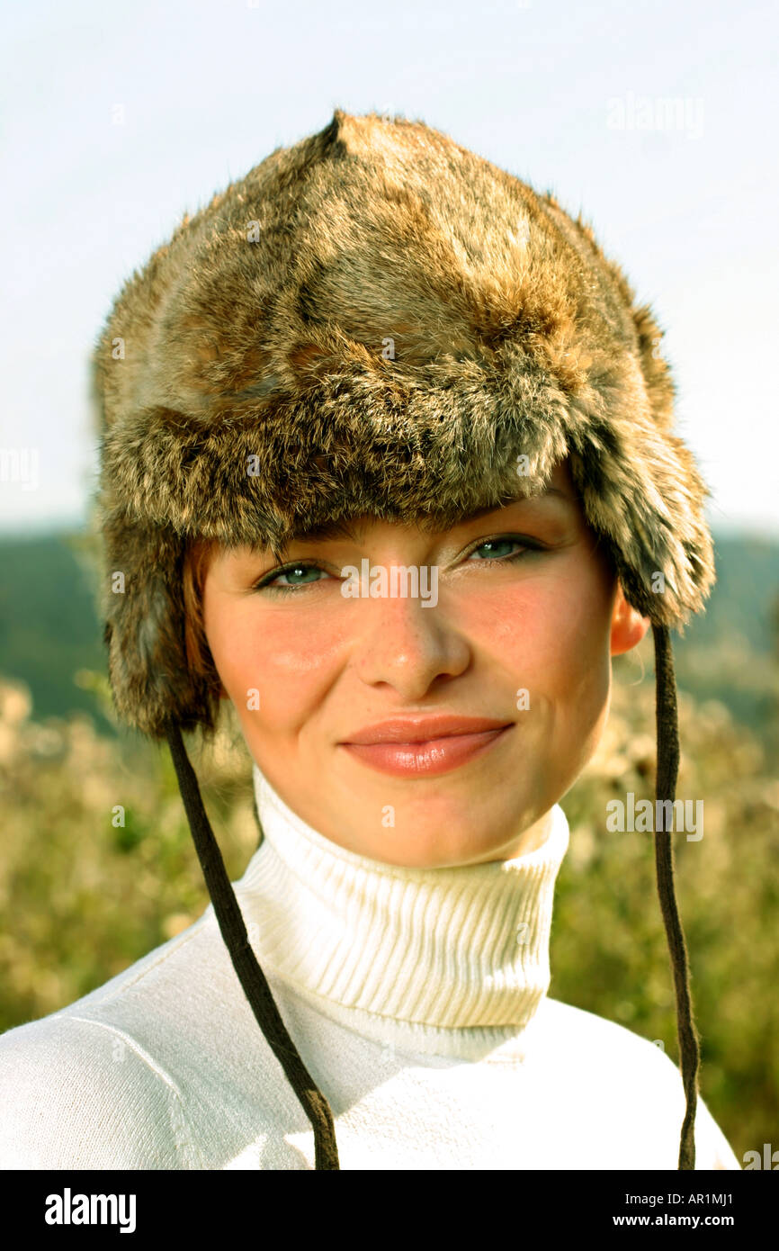 Outdoor giornata autunnale mead erba del campo vicino la donna giovane 25 30 cappuccio di pelliccia ritratto maglione golf jersey sorriso bianco sorridente verti Foto Stock