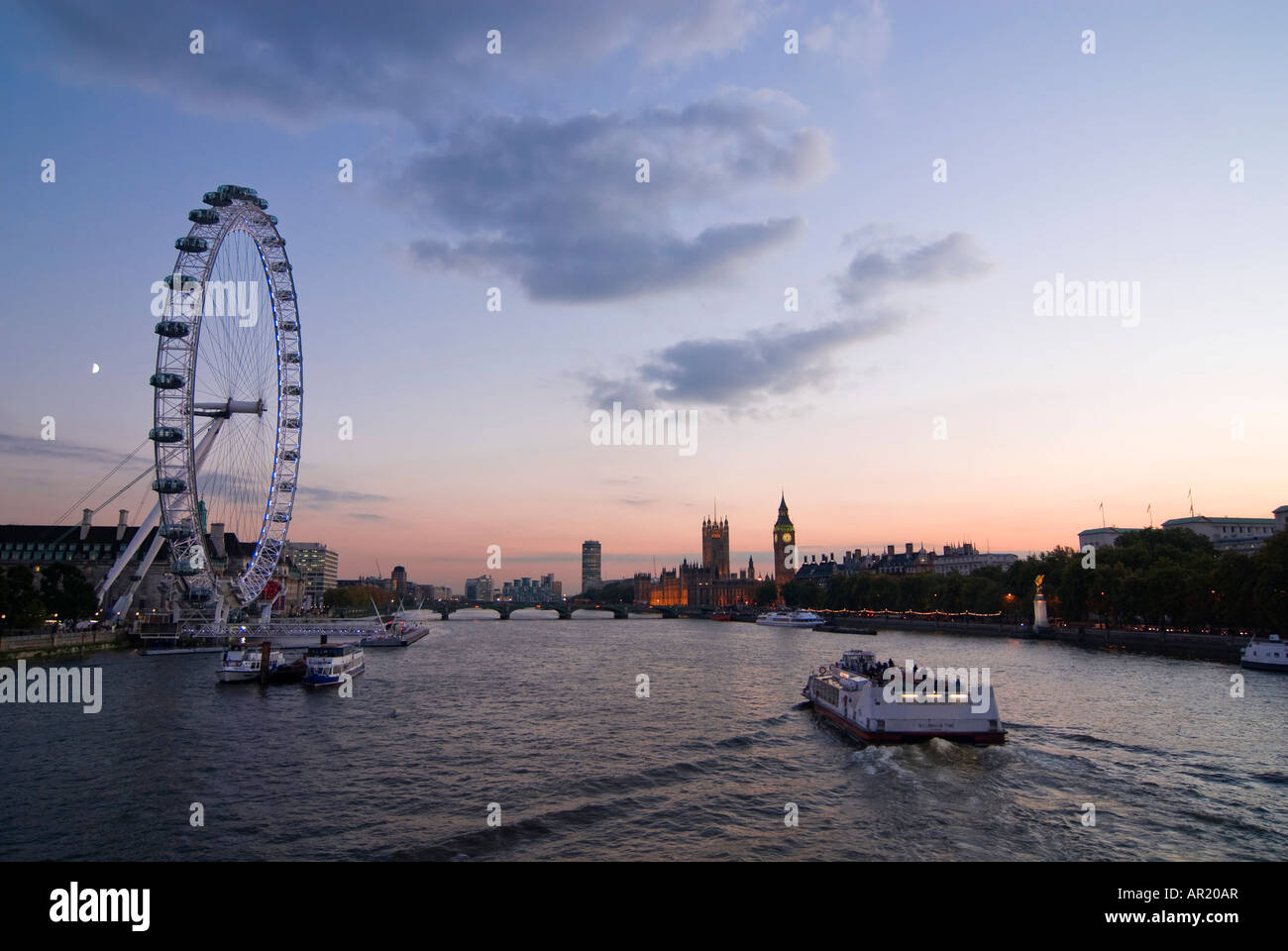 In orizzontale ampia angolazione del fiume Tamigi al tramonto con il London Eye Millenium ruota" e le case del Parlamento. Foto Stock