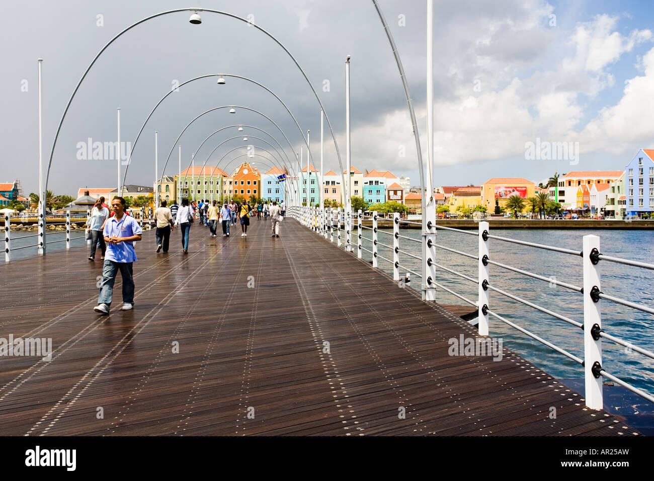 Le persone che attraversano il recentemente restaurato Queen Emma Bridge Willemstad Curacao dopo una breve doccia a pioggia Foto Stock