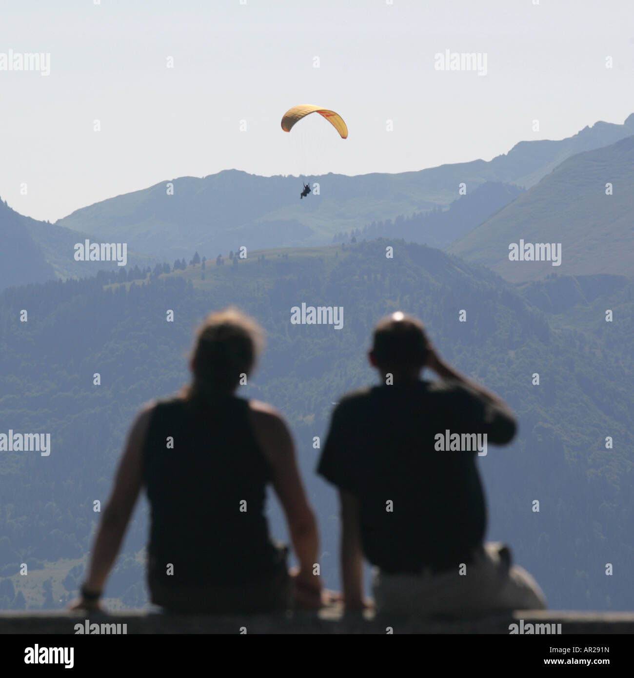 Un paio di guardare un para glider oltre le Alpi francesi. Foto Stock