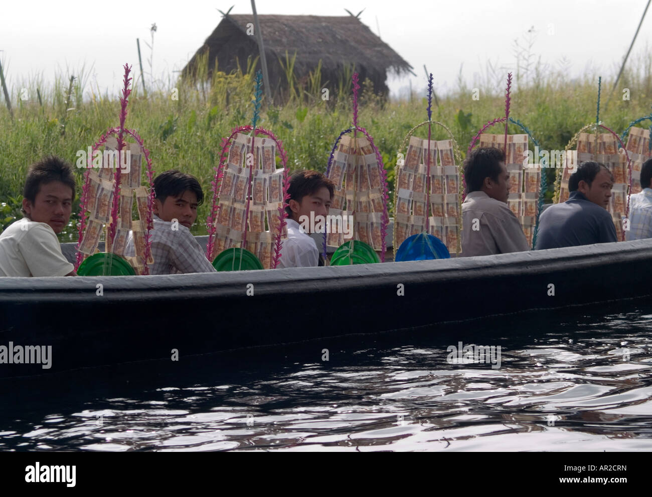 Ragazzi birmani in una barca con il denaro gli alberi per il tempio rendendo merito sul Lago Inle in Birmania Foto Stock