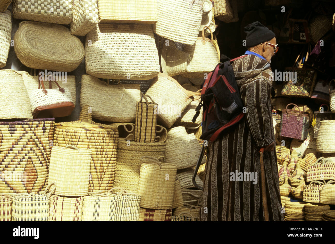 Uomo anziano a piedi passato stallo cestello, Essaouira, Marocco, Africa del Nord. Foto Stock