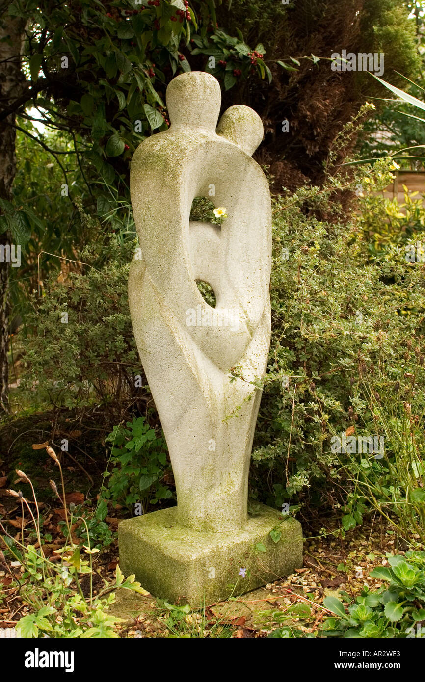 Statua del giardino con un piccolo fiore giallo Foto Stock
