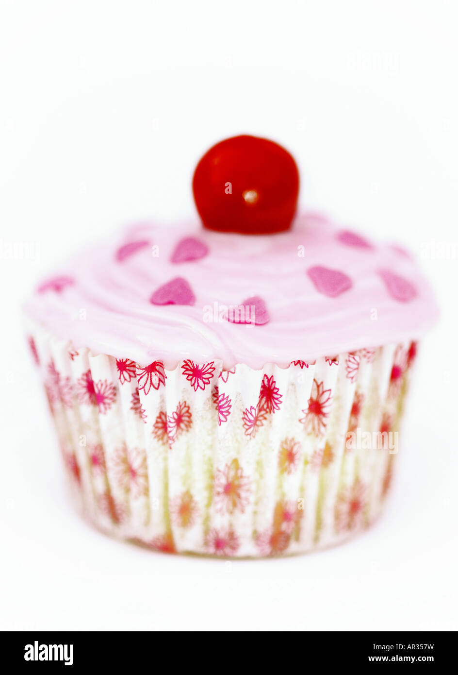 Home cotta Cup cake o torta di fata. Pan di Spagna con Rosa ghiaccio fondente, cuori di zucchero e una ciliegina sulla torta. Foto Stock