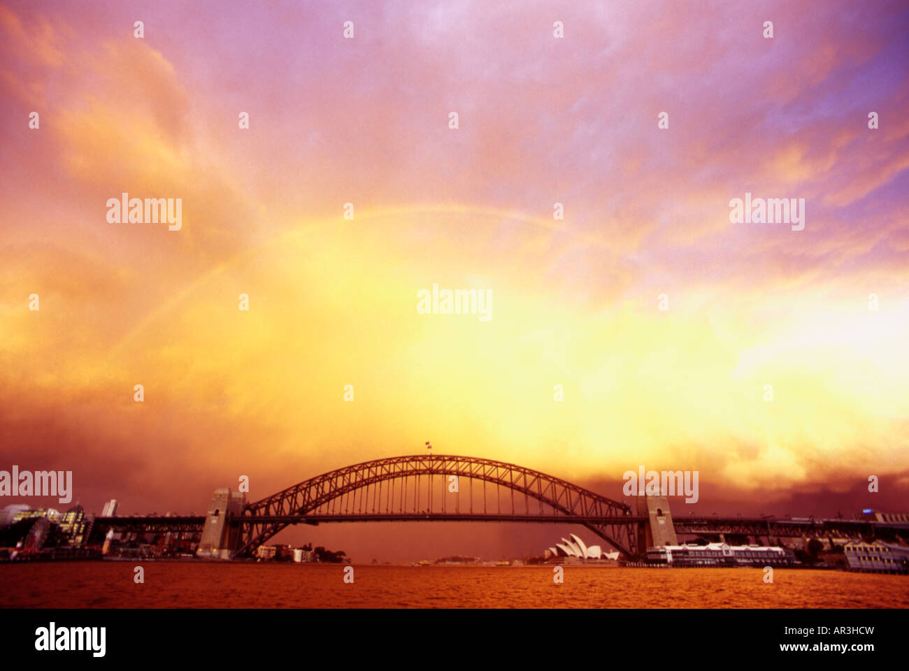 Tempesta su Sydney Harbour, illuminata in modo spettacolare tramonto da McMahon punto, Opera House di Sydney e il Sydney Harbour Bridge distanza Foto Stock