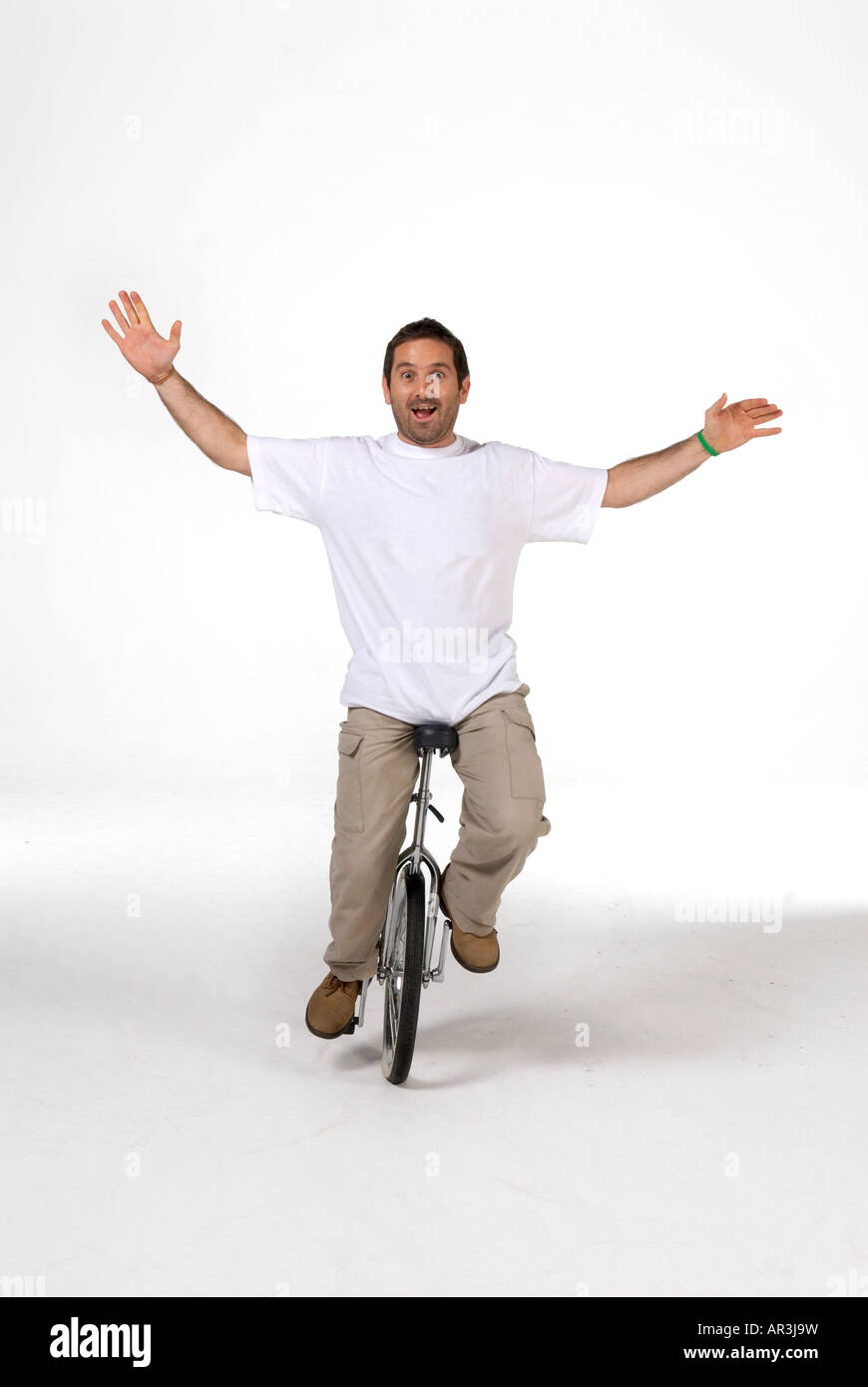 Un uomo che cavalca un monociclo in studio Foto Stock