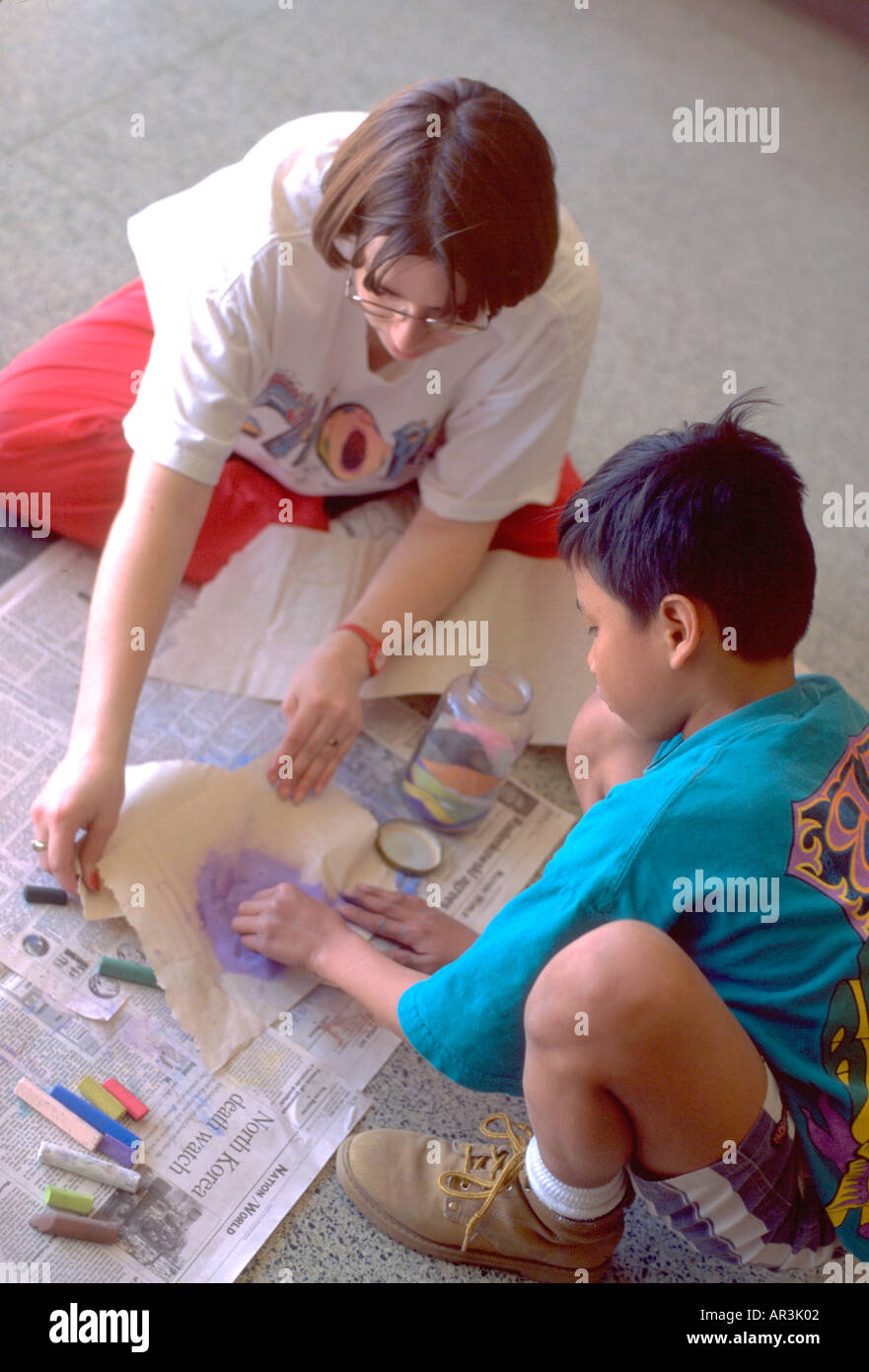 Asian studente età 8 e maestra età 20 con sabbia progetto arte nella scuola dopo il progetto di studio. St Paul Minnesota USA Foto Stock