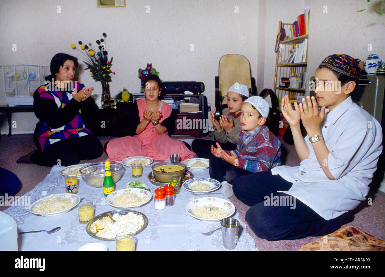 Clapton Londra - famiglia musulmana durante il Ramadan pregare prima di mangiare Foto Stock