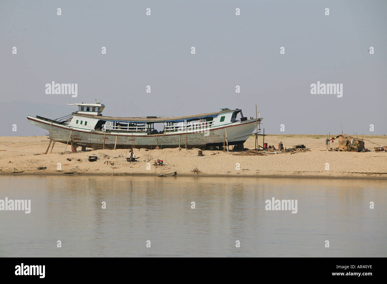 Riverside scenario, in barca nel bacino di carenaggio, fiume Irrawaddy scena vecchia barca essendo riparata in riverbank Boot am Ufer der Ayeyarwady Flus Foto Stock