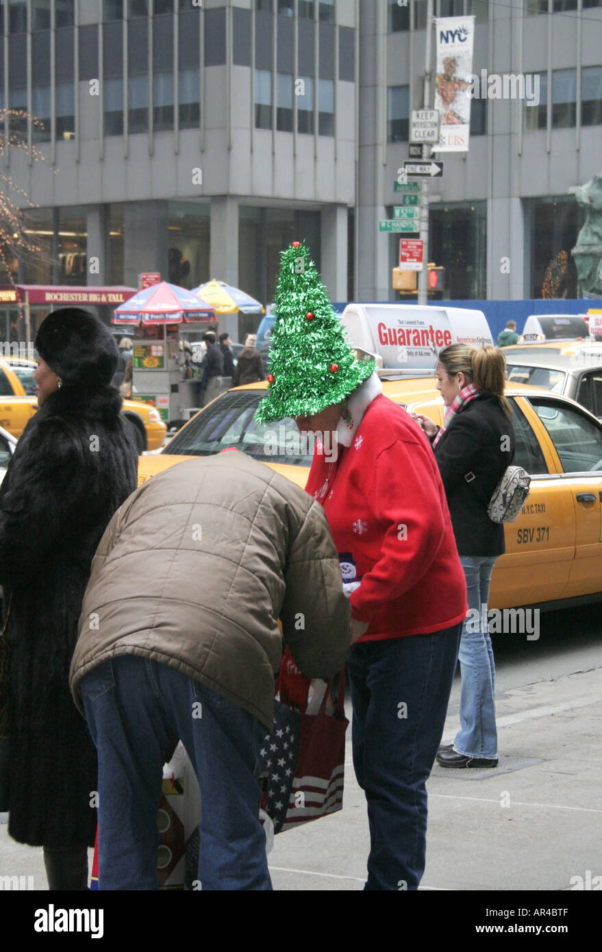 Gli amanti dello shopping. La città di New York. Novità albero di Natale hat. Vacanze Inverno stagione street scene. Stati Uniti d'America. Foto Stock