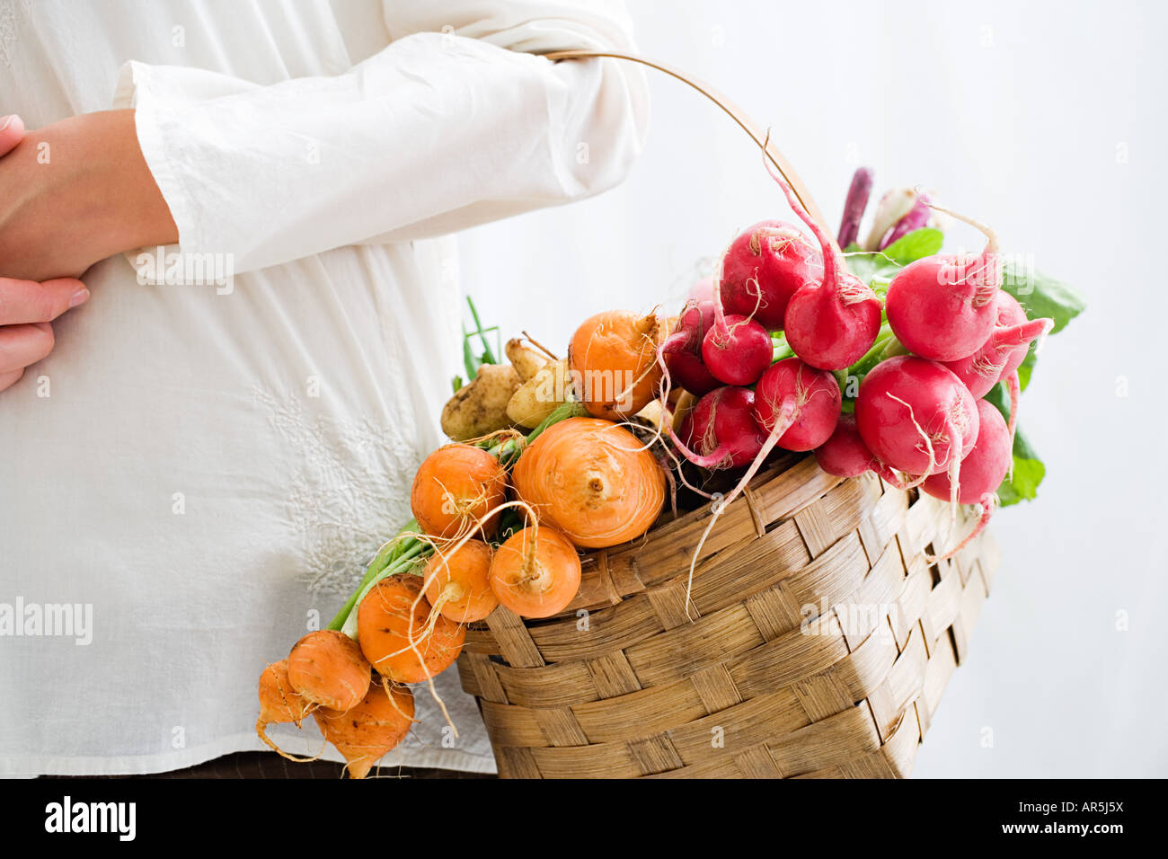 Donna cestello di contenimento di barbabietole e ravanelli Foto Stock