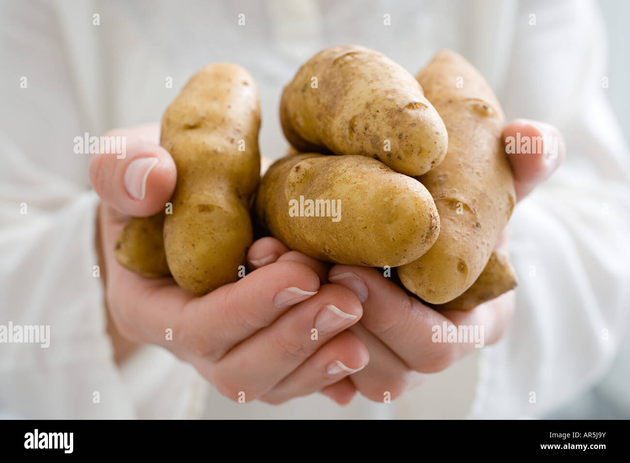 Persona in possesso di fingerling patate Foto Stock