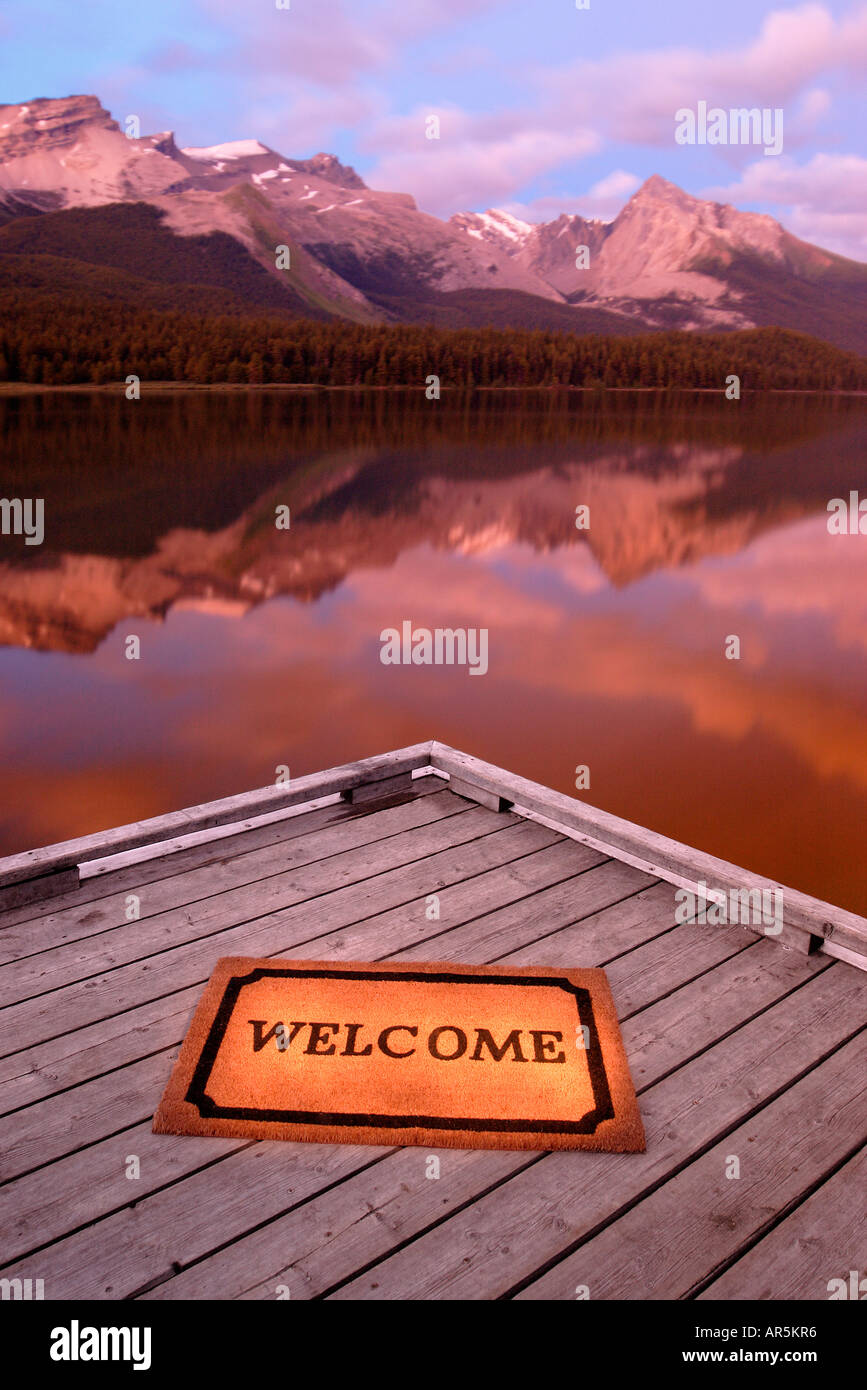 Tappeto di benvenuto sul dock con le montagne e il lago Foto Stock