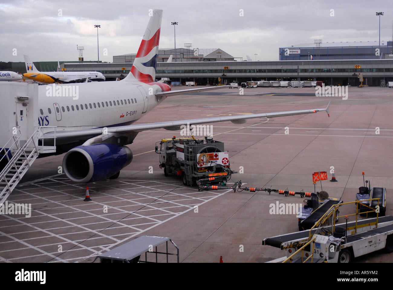 Un British Airways aeromobile è rifornito da un combustibile bowser carrello a terra all'Aeroporto Internazionale di Manchester Foto Stock