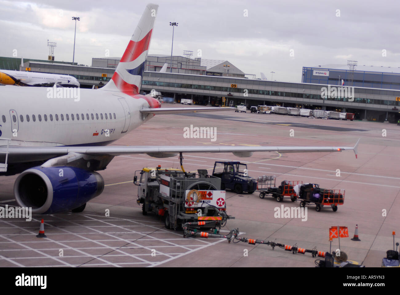 Un British Airways aeromobile è rifornito da un combustibile bowser carrello a terra all'Aeroporto Internazionale di Manchester Foto Stock