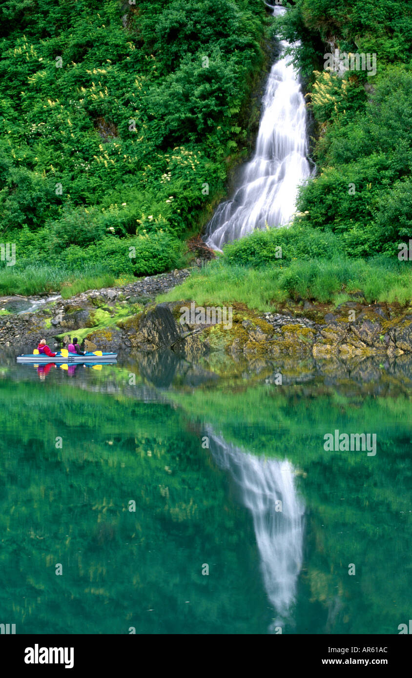 Stati Uniti d'America Alaska sud-est una coppia in un kayak paddling le acque del ghiacciaio guardando una bella cascata Foto Stock