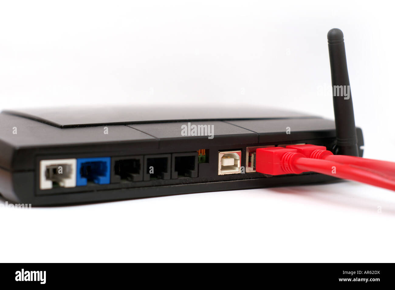 Backsite di un router isolati su sfondo bianco due delle porte sono il rosso dei cavi di rete collegato alla presa di corrente Foto Stock