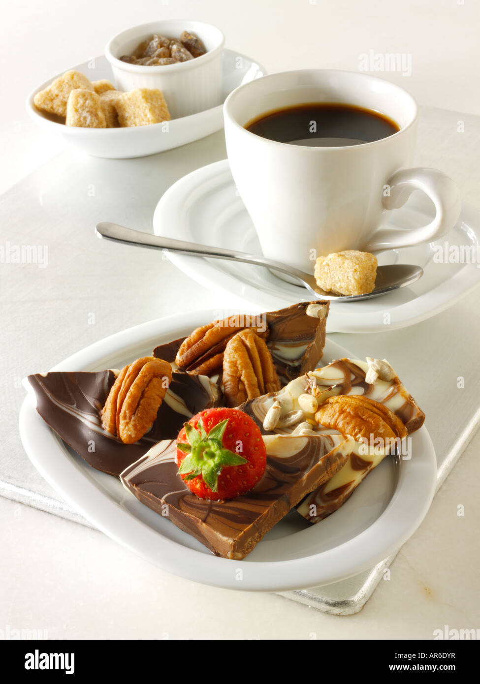 Il cioccolato turbinii piazze con fragole fresche e noci pecan su un vassoio con un caffè nero. Foto Stock