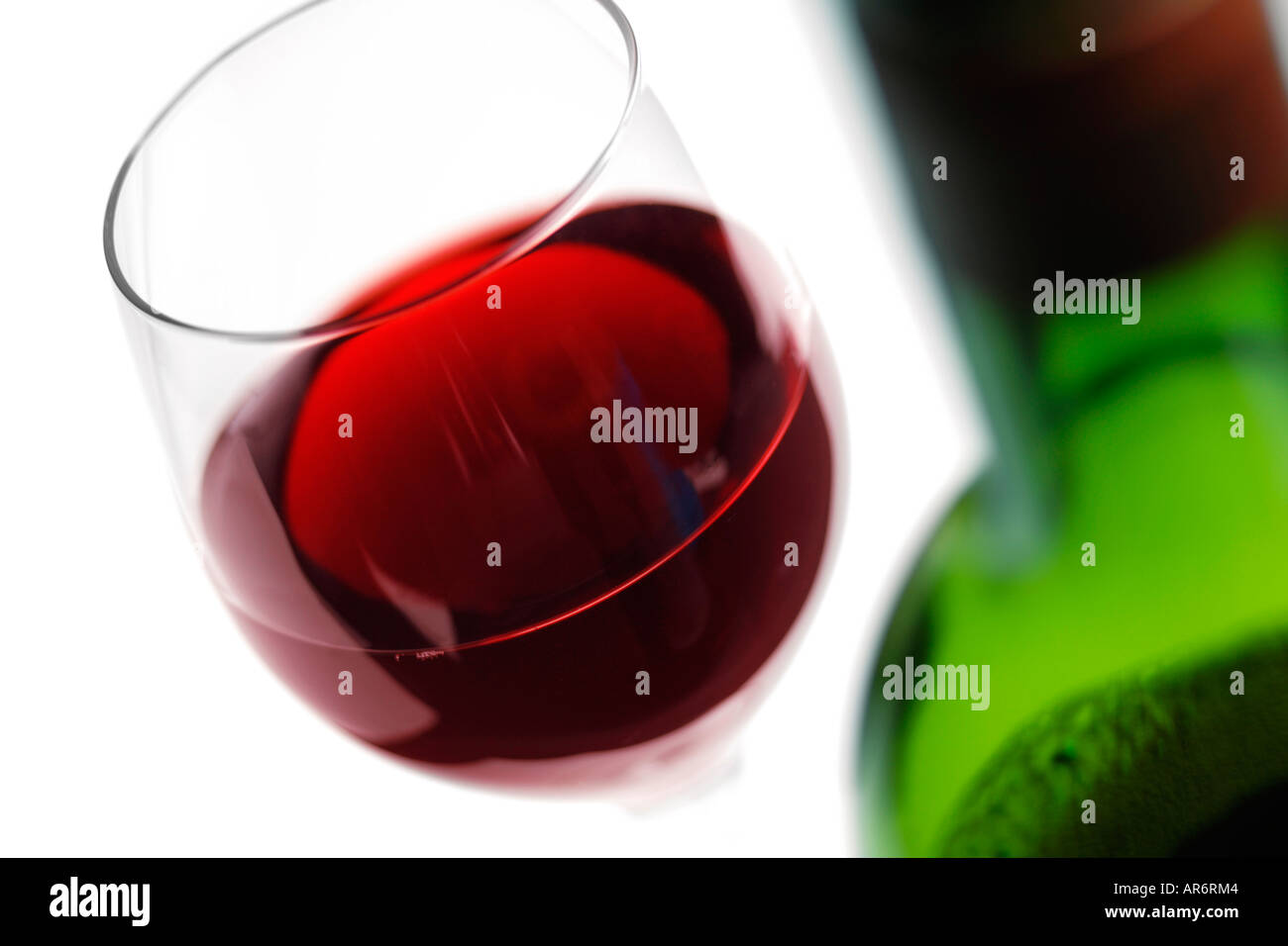 Bicchiere di vino rosso con bottiglia in primo piano Foto Stock