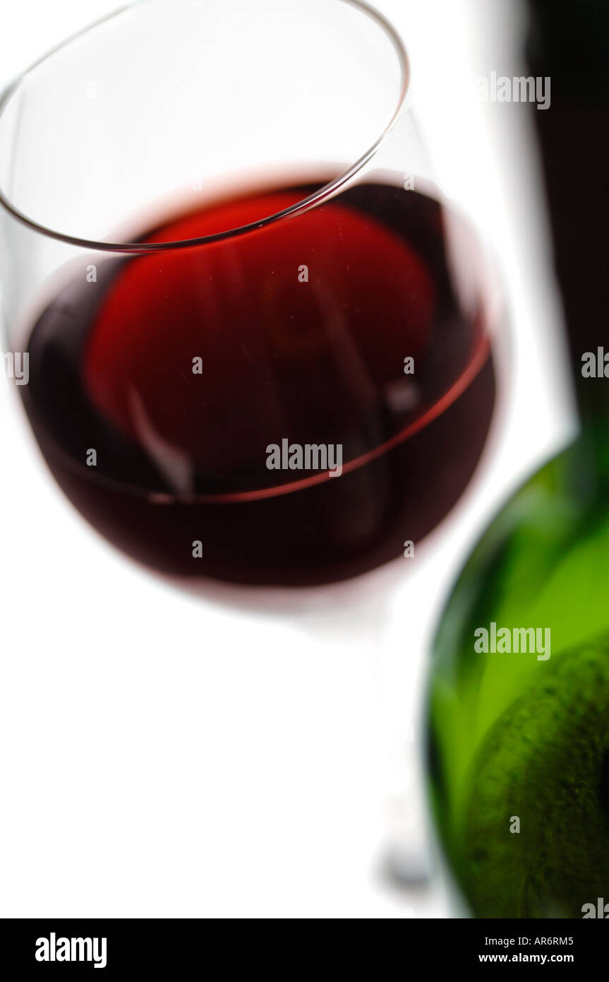 Bicchiere di vino rosso con bottiglia in primo piano Foto Stock