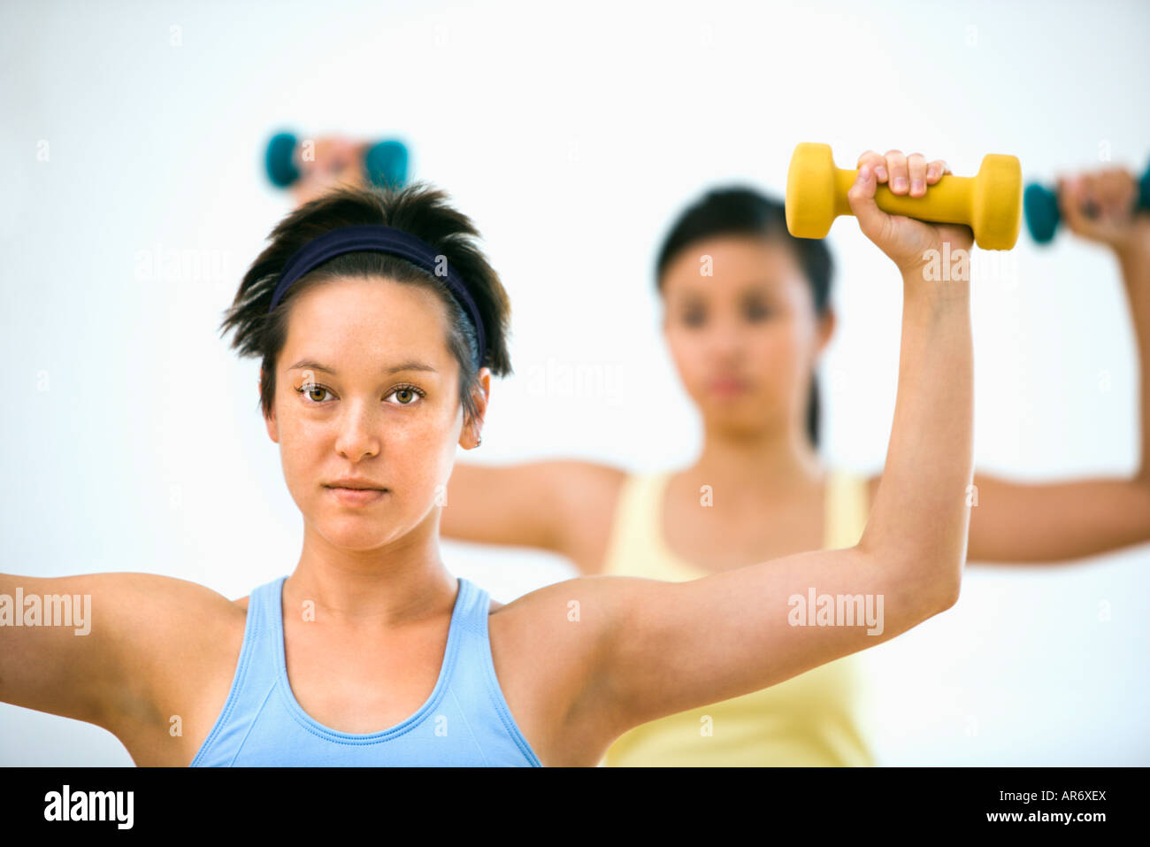 Giovani donne presso la palestra di sollevamento pesi a mano Foto Stock