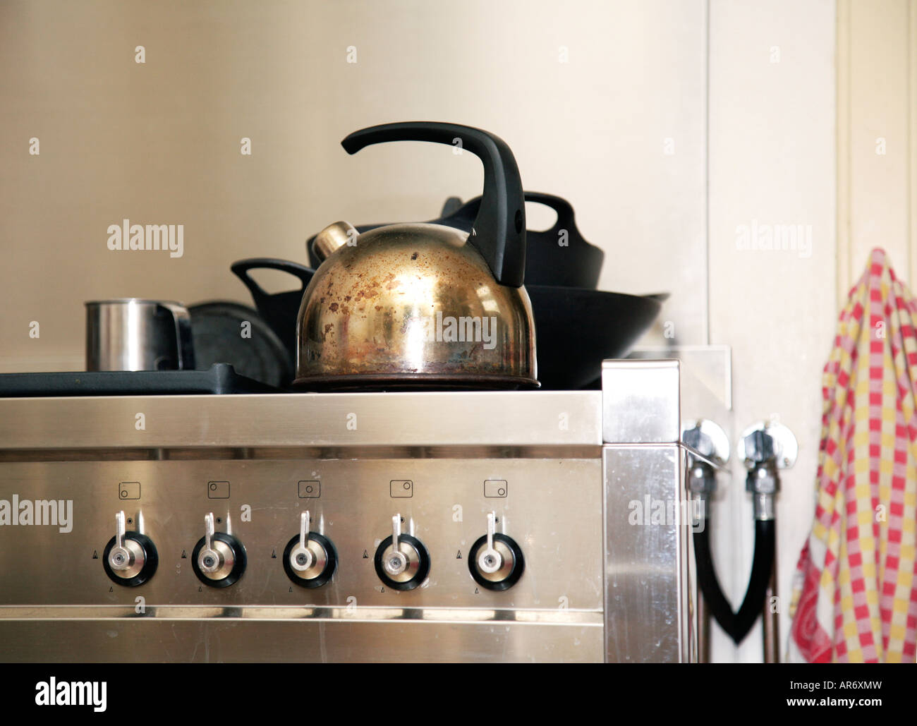 Scena da cucina in acciaio inox stufa con bollitore d' acqua asciugamano e del tubo flessibile di gas Foto Stock