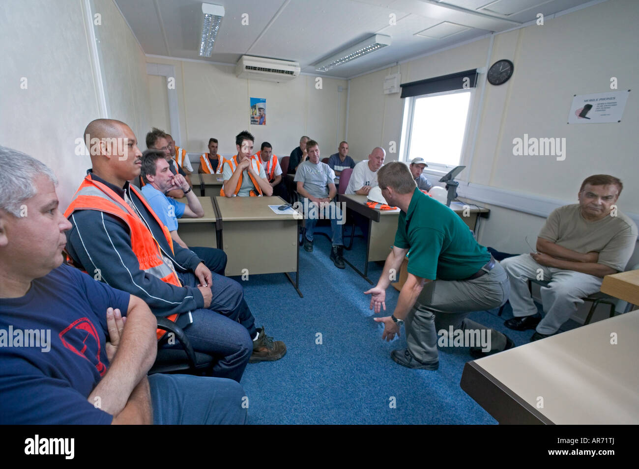 Istruttore insegna pesanti corretto-tecniche di sollevamento per i lavoratori del settore ferroviario per cercare di prevenire gravi lesioni indietro su rampa siti. Foto Stock