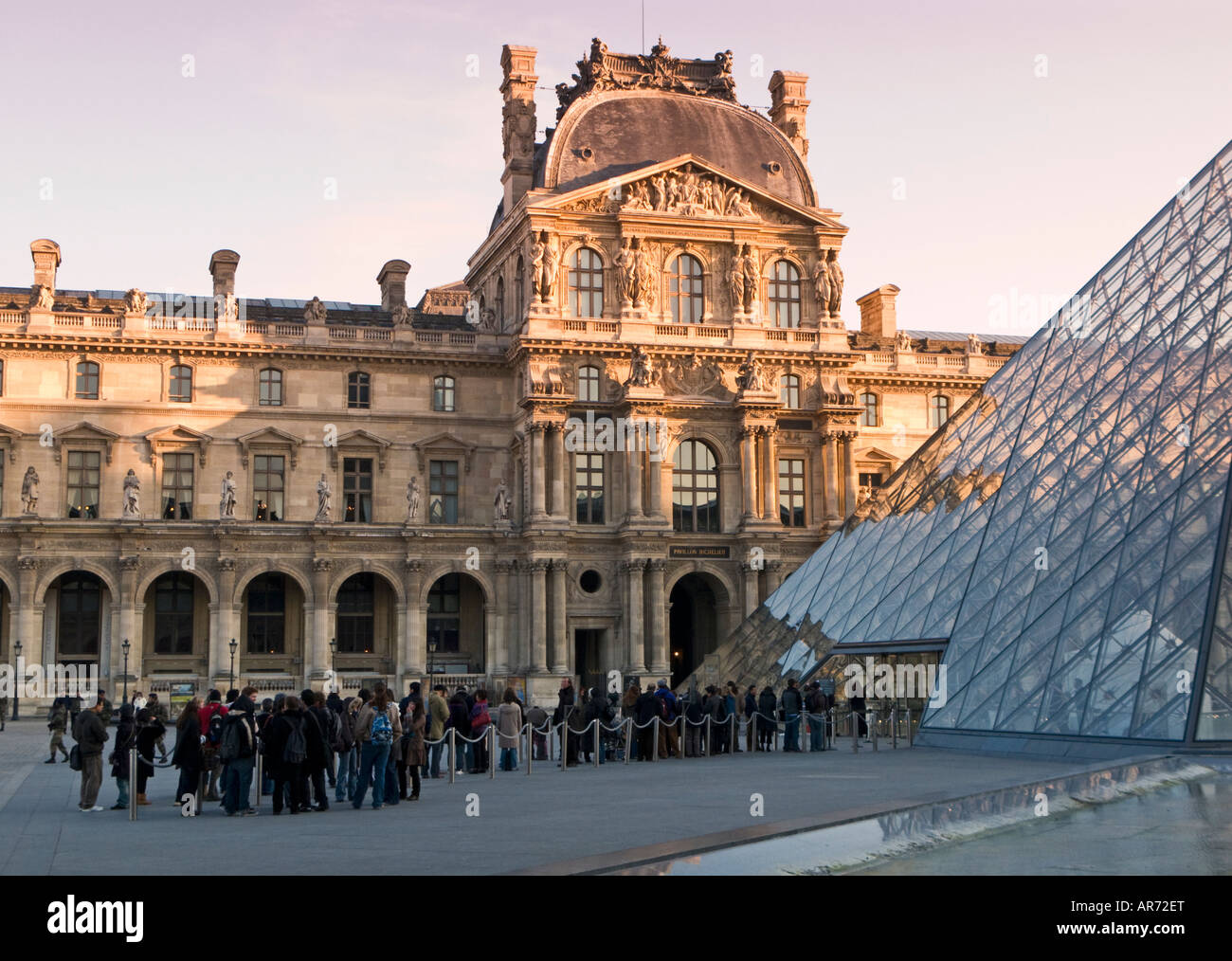 I visitatori in coda fino al mattino presto a piramide ingresso al museo del Louvre Parigi Francia Europa Foto Stock