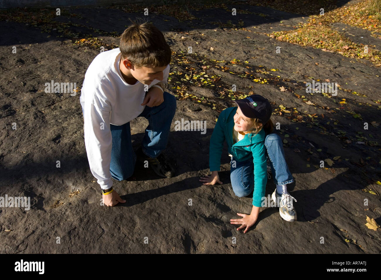 Un fratello e una sorella guarda un footprint dinsaur vicino al fiume Connecticut in Holyoke, Massachusetts. Foto Stock